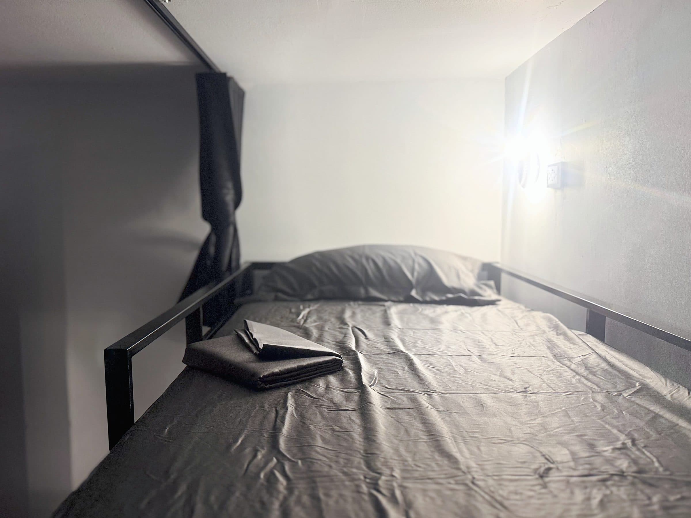Made-up bunk with fresh towels and a reading light